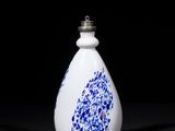 a white and blue vase sitting on top of a black table