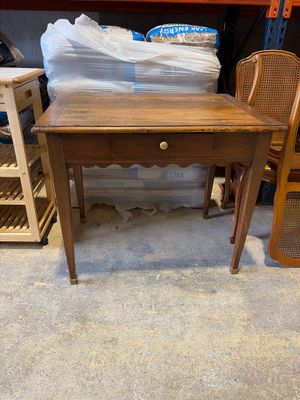 une petite table avec un tiroir, placée au milieu d'une pièce