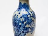 un vase bleu et blanc posé sur une surface blanche