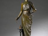 statue en bronze d'une femme tenant un oiseau sur un piédestal