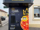 un distributeur automatique de pizzas installé contre un immeuble