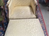 un fauteuil et un pouf au milieu d'une pièce