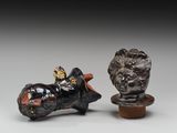 deux petites sculptures représentant un homme à moto et un lion