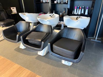 trois fauteuils dans un salon équipé de deux lavabos et d'un miroir
