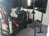 un bureau d'ordinateur équipé de deux écrans et d'un simulateur de course