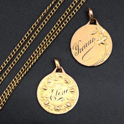 two gold medallions with the names of two people on them