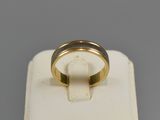 a close up of a gold ring on a white stand