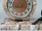 a clock that is sitting on a marble stand