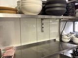 de nombreux plats et casseroles sur les étagères de la cuisine