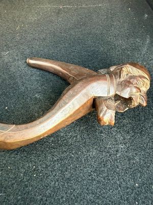 a wooden pipe holder with a carved elephant head on it