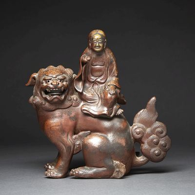 chinese bronze figure of a seated person on a seated lion