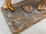 a bronze statue of a man holding a baseball bat