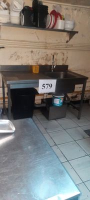 une cuisine équipée d'un évier et d'un plan de travail sur lequel est posée une pancarte
