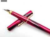 two pens sitting on top of each other on a white surface
