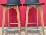 two black stools sitting next to each other on a tiled floor