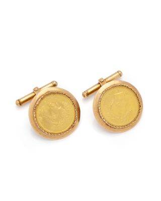 a close up of a pair of gold cufflinks on a white background