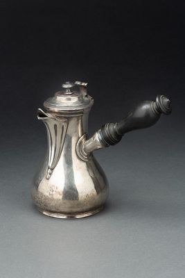 une théière en argent avec une anse sur une table