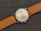 une image représentant une montre avec un bracelet en cuir marron sur un fond noir