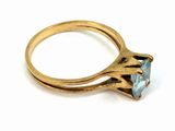 an image of a gold ring with a blue topaz stone