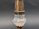 un vase ancien en laiton et en cristal taillé, muni d'un couvercle et posé sur un socle