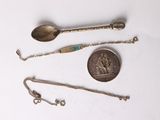 a silver spoon, a silver spoon, and a silver spoon on a white surface