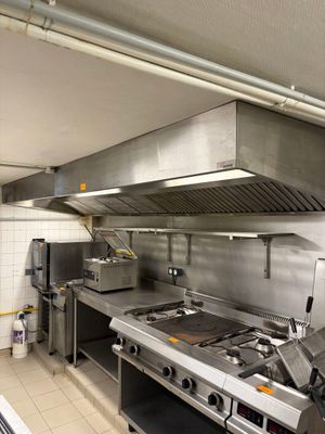 a large commercial kitchen with stainless steel appliances in it