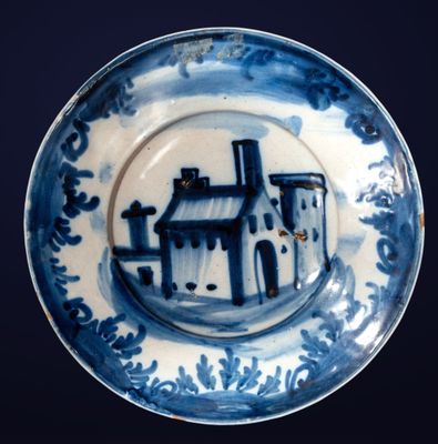 une assiette bleue et blanche sur laquelle est représenté un château