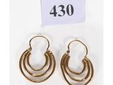 une paire de boucles d'oreilles en or sur fond blanc