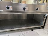 a stainless steel counter with three burners on top of it