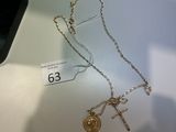 un collier en or orné d'une croix et d'une pièce d'or