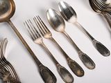 a lot of silver spoons and forks on the table