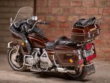 a brown motorcycle parked in front of a brick wall