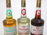 three bottles of liquor are lined up on a white surface