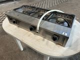 a gas stove on a table in a kitchen
