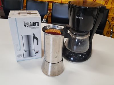 a coffee maker sitting on a table next to a box of coffee