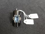 une bague sertie d'une pierre bleue, avec une étiquette de prix