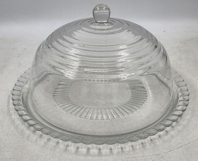 un plat à gâteau en verre muni d'un couvercle bombé