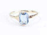 a close up of a ring with a blue stone in it