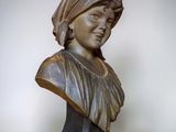 bronze bust of a woman wearing a headscarf on a black stand