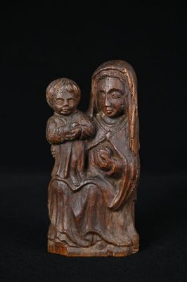 une statue en bois représentant une femme tenant un enfant sur ses genoux