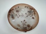 a brown and white plate with a design on it