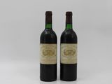 two bottles of wine sitting next to each other on a white surface