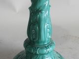 a green candle that has a bird on top of it