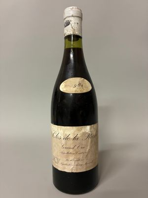 an old bottle of wine sitting on top of a table