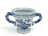 un vase bleu et blanc muni d'anses, sur un fond blanc