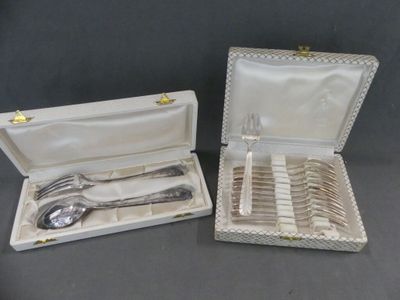 deux pièces d'argenterie dans un coffret posé sur une table