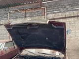 an old car with its hood open sitting in a garage