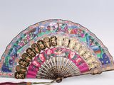 a fan that is sitting on a table with a tassel