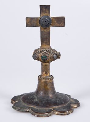 une vieille croix en bronze ornée d'une pierre verte en son centre
