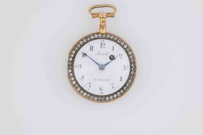 a close up of a gold and diamond watch on a white surface